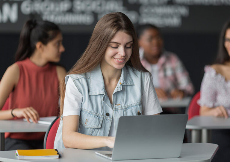 moça numa sala de aula a utilizar seu notebook