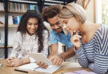 Resultado FIES 2023: três estudantes jovens olham para tela de um tablet enquanto acessam o resultado do Fies.
